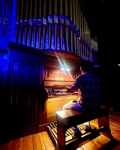 A musician playing the pipe organ inside The Organ Barn