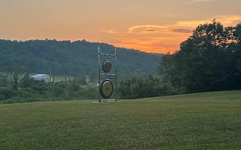 Gongs set up in a meadow at sunset