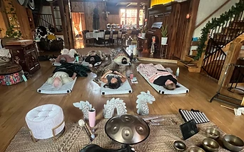 A group sound bath laid out beneath the pipe organ