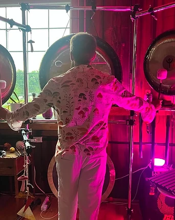 Striking a hanging gong in magenta light