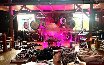 A sound bath bathed in magenta and purple light inside the barn