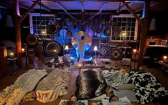 A sound bath practitioner playing a suspended gong