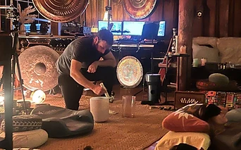 A practitioner playing a crystal singing bowl inside the barn