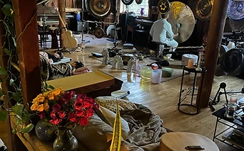 A sound bath in session with candlelight and a golden gong