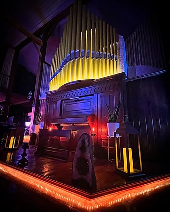 The pipe organ bathed in violet and red light