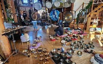 A sound healing setup of gongs and singing bowls in the barn