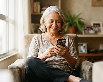 Senior woman smiling while using her phone in soft natural light