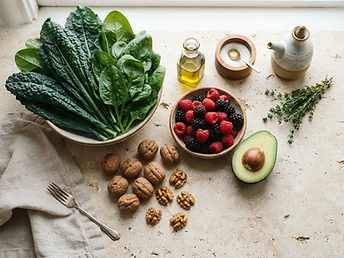 Overhead still life of fresh greens, berries, avocado and walnuts