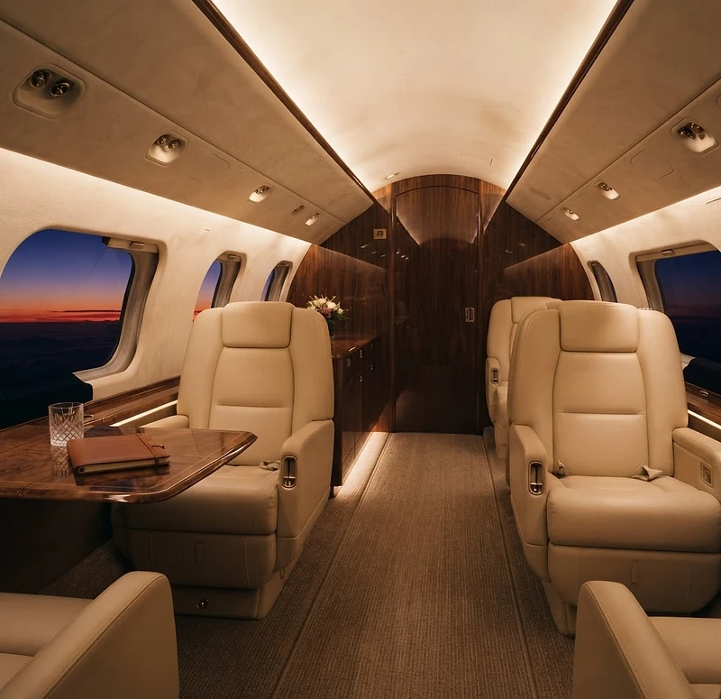 The cream leather cabin of a private jet at dusk