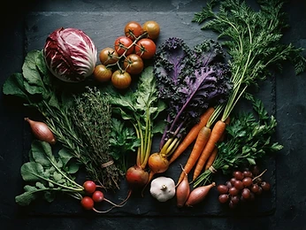 Fresh vegetables and herbs on dark slate