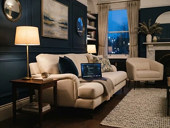 An elegant living room with a laptop in evening lamplight
