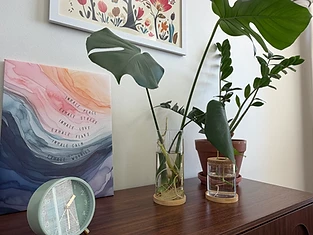 Warm office details — plants, art, and a sage-green clock