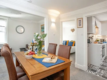 The dining table for two, with the kitchen and bedroom beyond