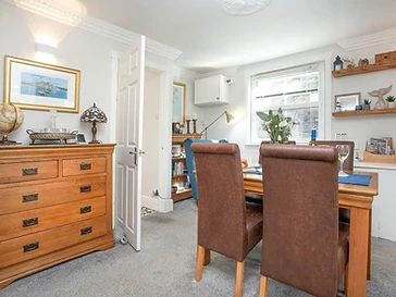 The dining room, with an oak chest and nautical prints