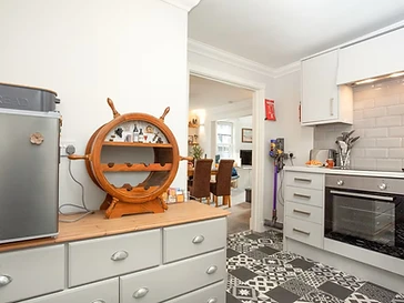 A ship's wheel wine rack and patterned tiles in the kitchen