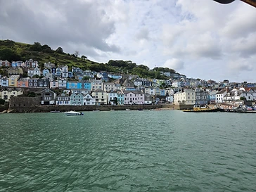 Pastel waterfront houses climbing the hillside, seen from the crossing