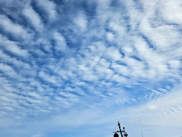 A mackerel sky over the estuary, with the Hauley V ferry tug on the water