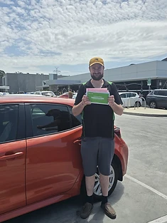 A happy Green Signals Driving School student holding their VicRoads congratulations certificate after passing at Mitcham.