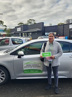 A happy Green Signals Driving School student holding their VicRoads congratulations certificate after passing at Mitcham.