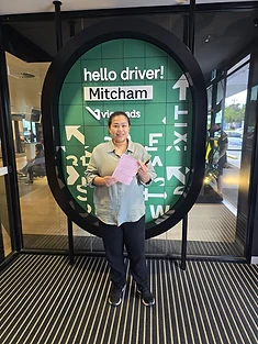 A happy Green Signals Driving School student holding their VicRoads congratulations certificate after passing at Mitcham.