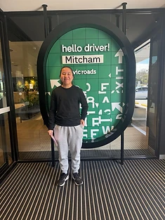 A happy Green Signals Driving School student holding their VicRoads congratulations certificate after passing at Mitcham.
