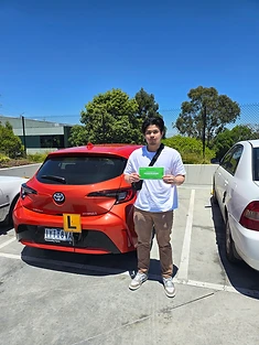 A happy Green Signals Driving School student holding their VicRoads congratulations certificate after passing at Mitcham.