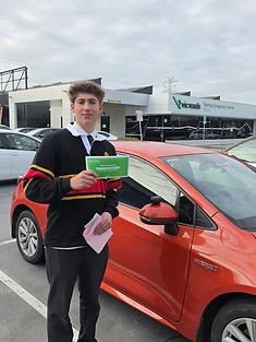 A happy Green Signals Driving School student holding their VicRoads congratulations certificate after passing at Mitcham.