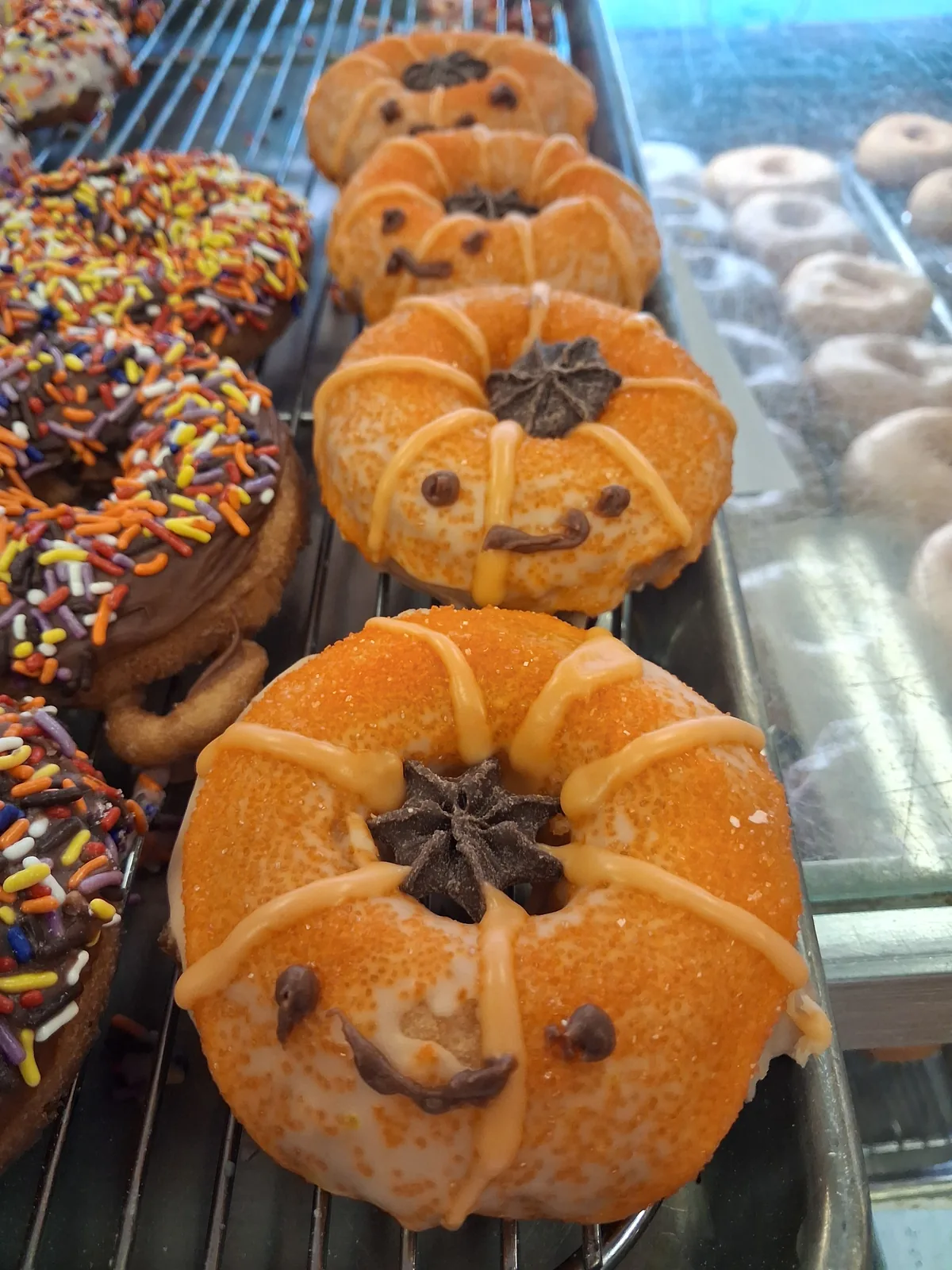 A tray of hand decorated jack-o-lantern donuts at Doughboys Donuts