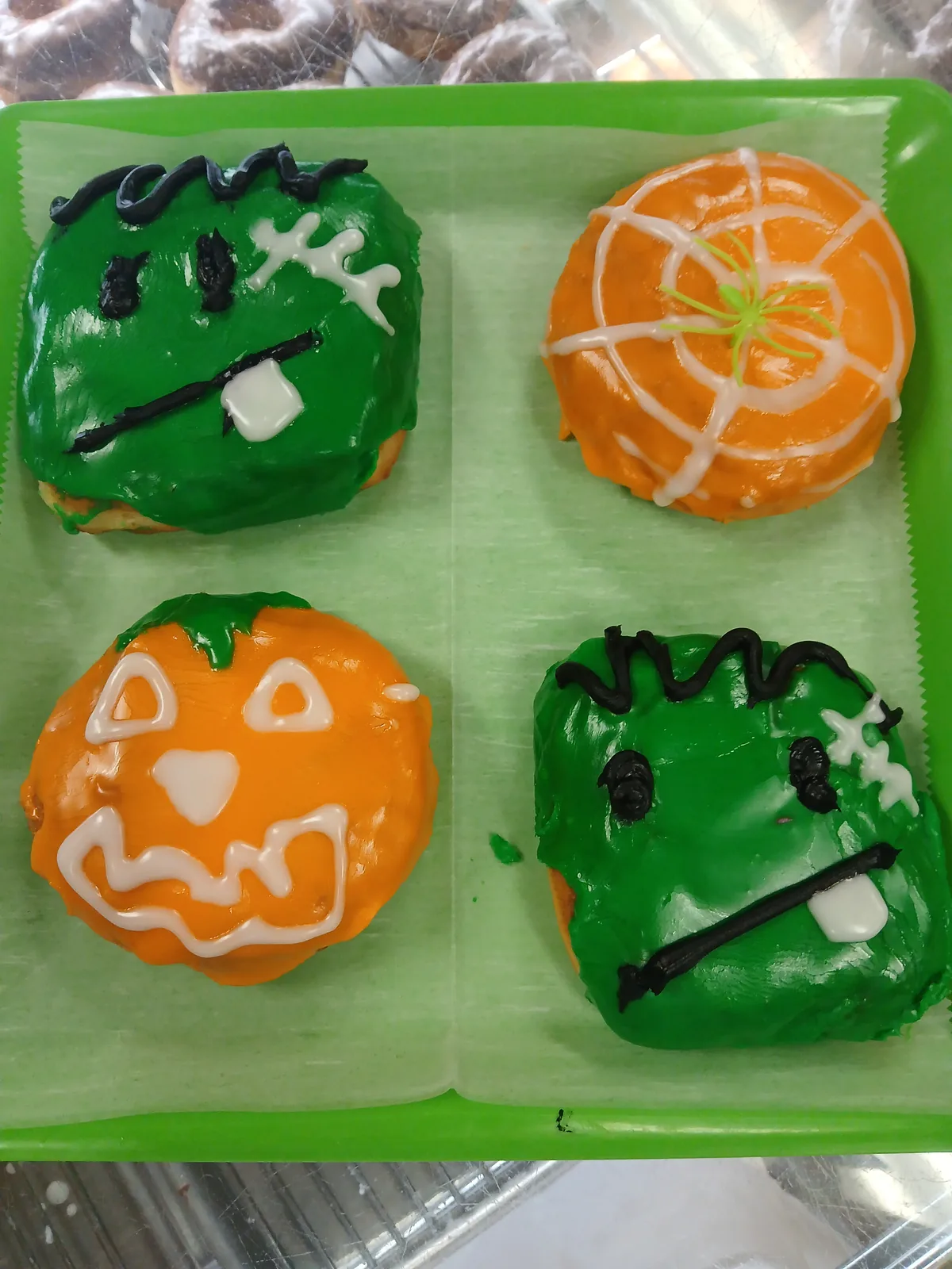 A box of four decorated Halloween donuts ready to go