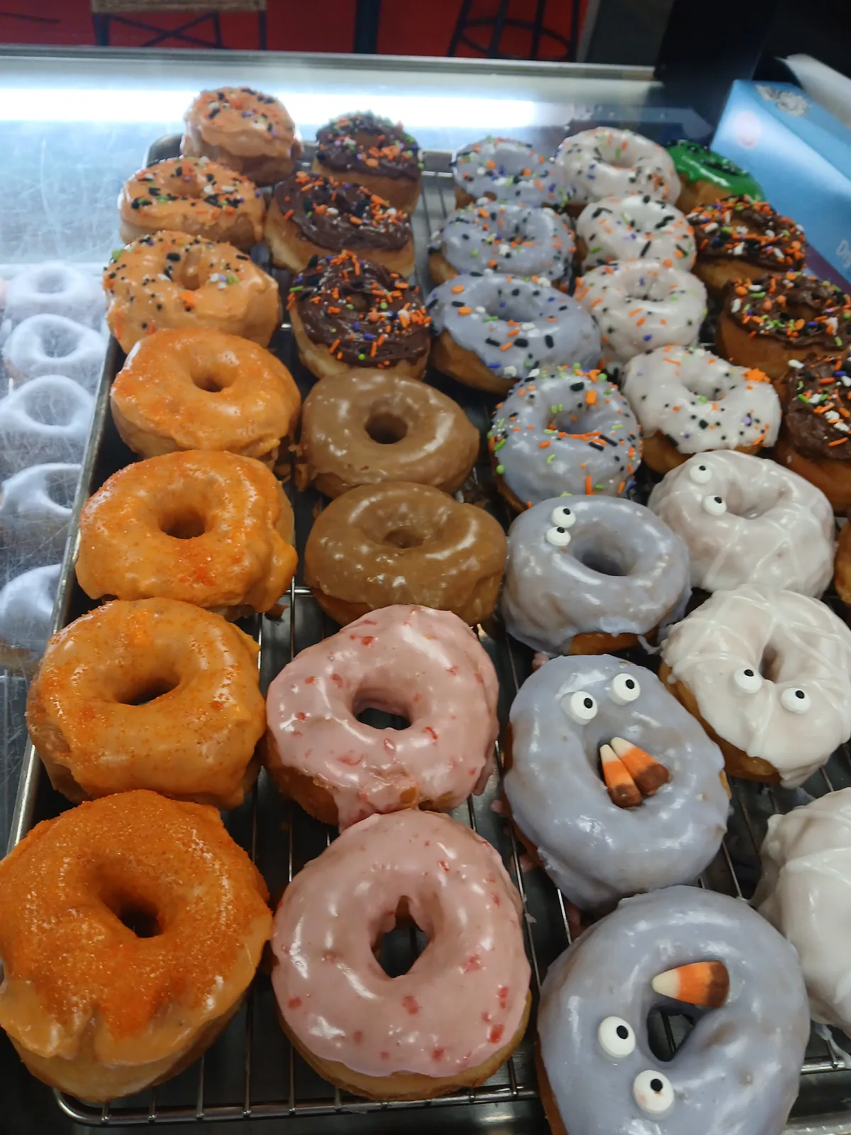 The Doughboys case filled with orange, white and chocolate Halloween donuts