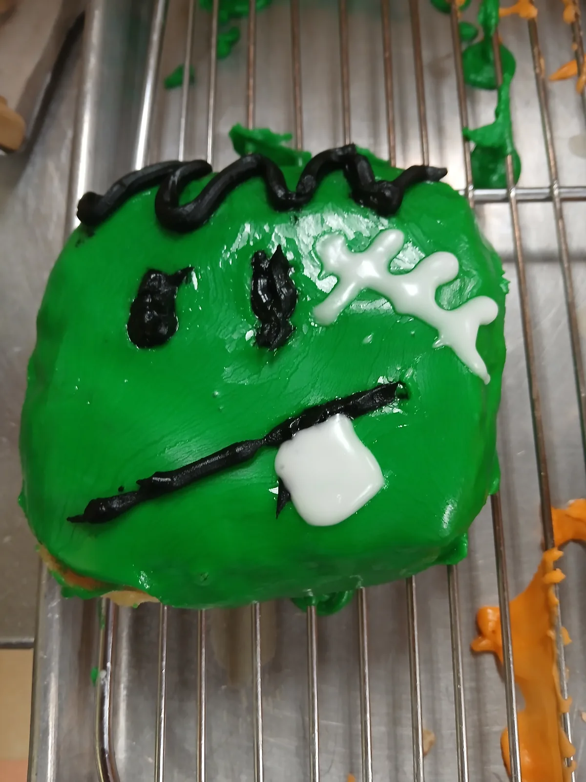 A green Frankenstein donut decorated by hand