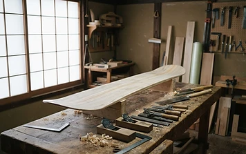 Hand-shaped snowboard core on a workbench