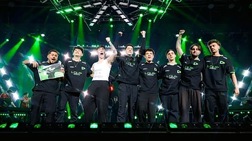 The LOUD squad on stage in black and green jerseys under green stage lights after winning the title.
