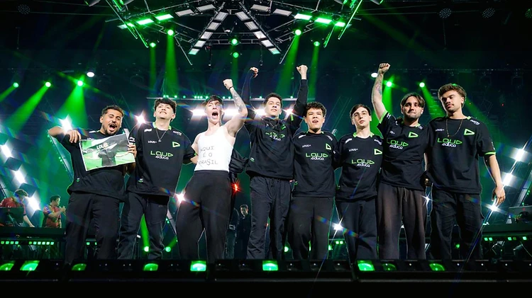 The LOUD squad on stage in black and green jerseys under green stage lights after winning the title.