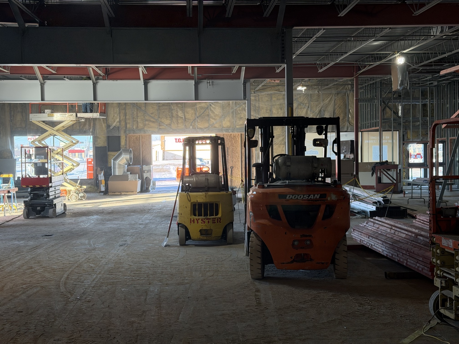 Commercial construction site interior with forklifts and equipment