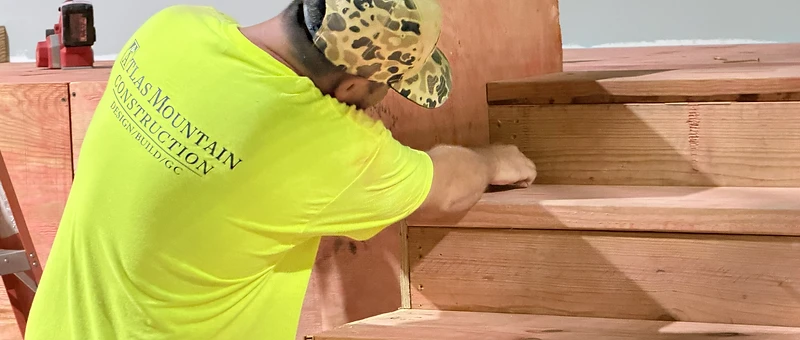Atlas Mountain Construction crew member framing wooden stairs