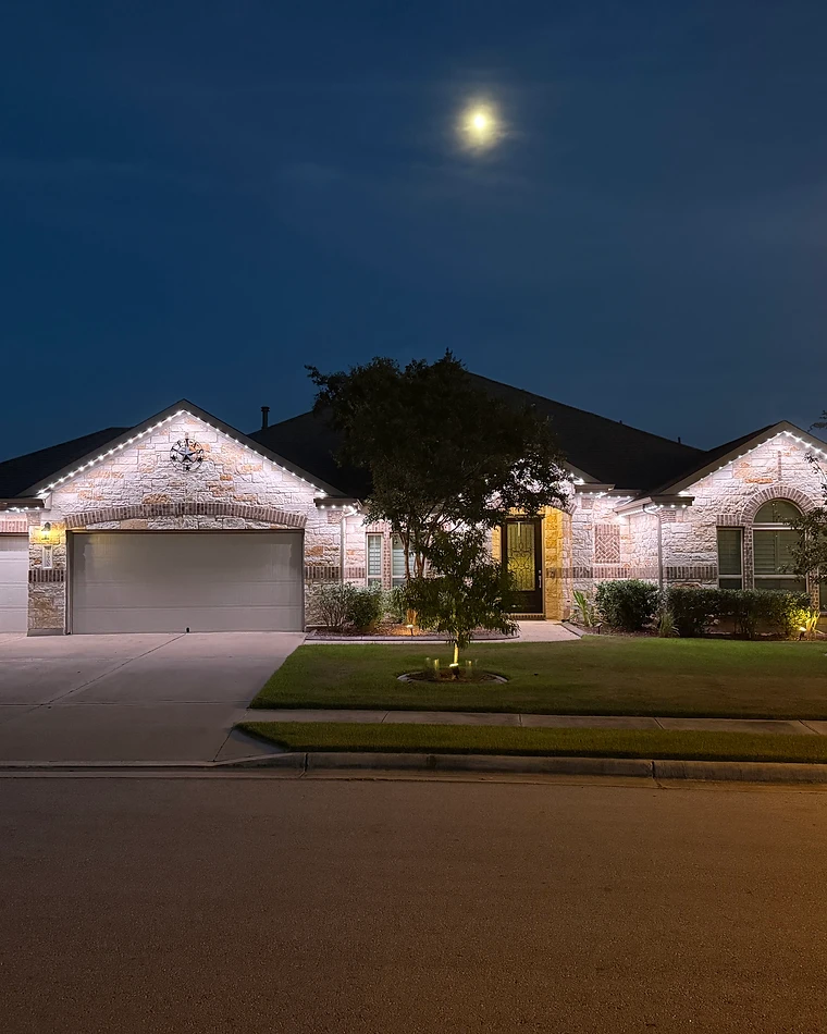 Architectural detail of a luxury home facade with warm white grazing light