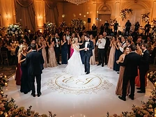 Round white acrylic dance floor with projected monogram at a wedding