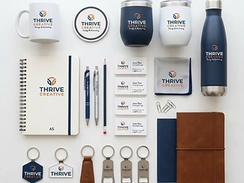 Branded promotional products including pens, mugs, tumblers, keychains, business cards, and stationery