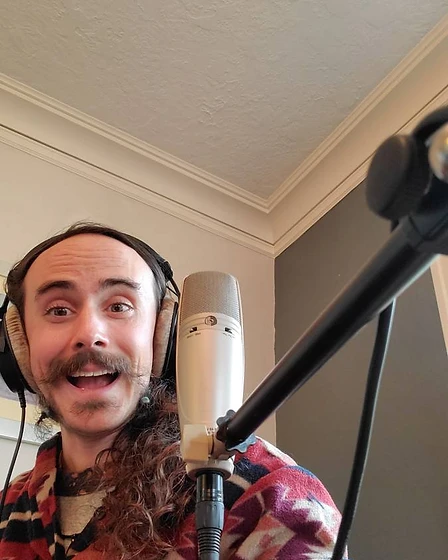 Fish wearing studio headphones at a microphone, smiling