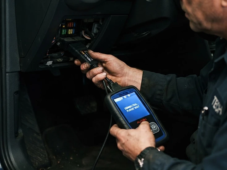 Mechanic using an automotive diagnostic scanner