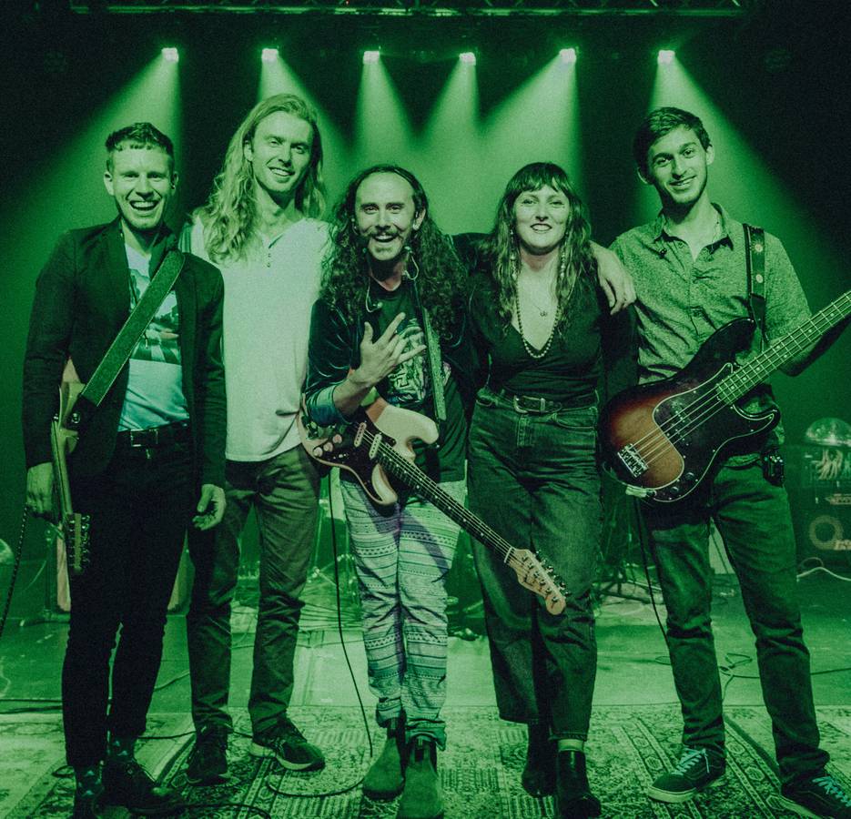 Fish performing live on stage with the band under green stage lighting