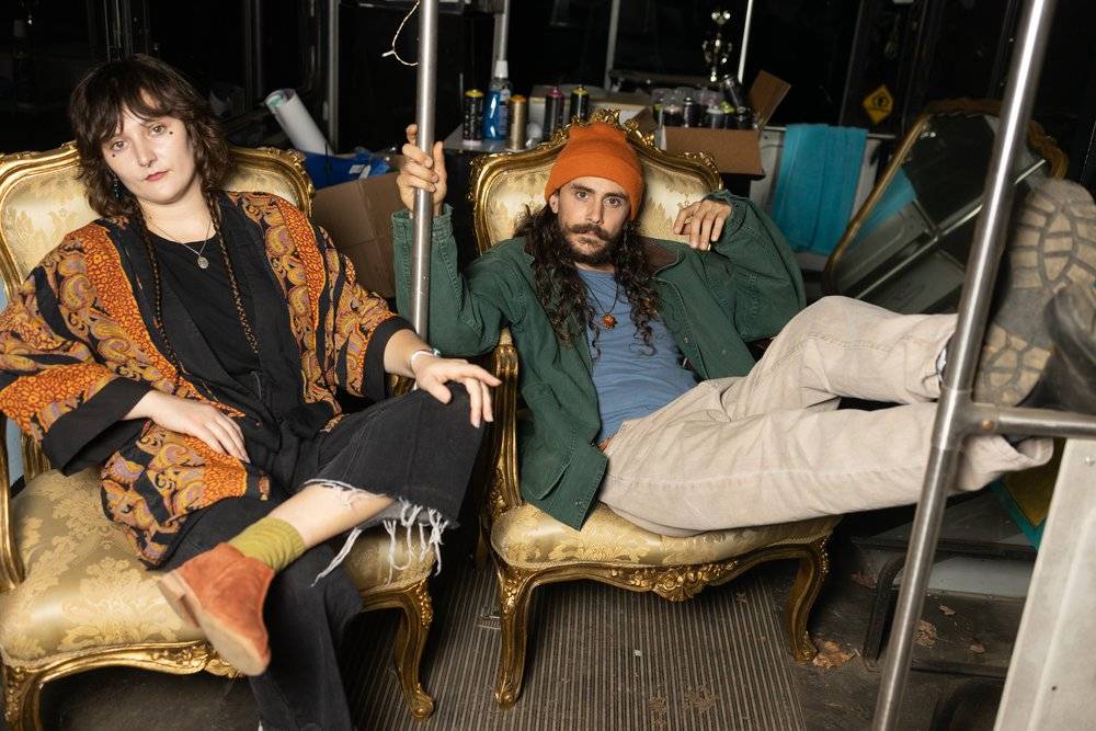 Fish and a bandmate relaxing in ornate gold vintage armchairs backstage