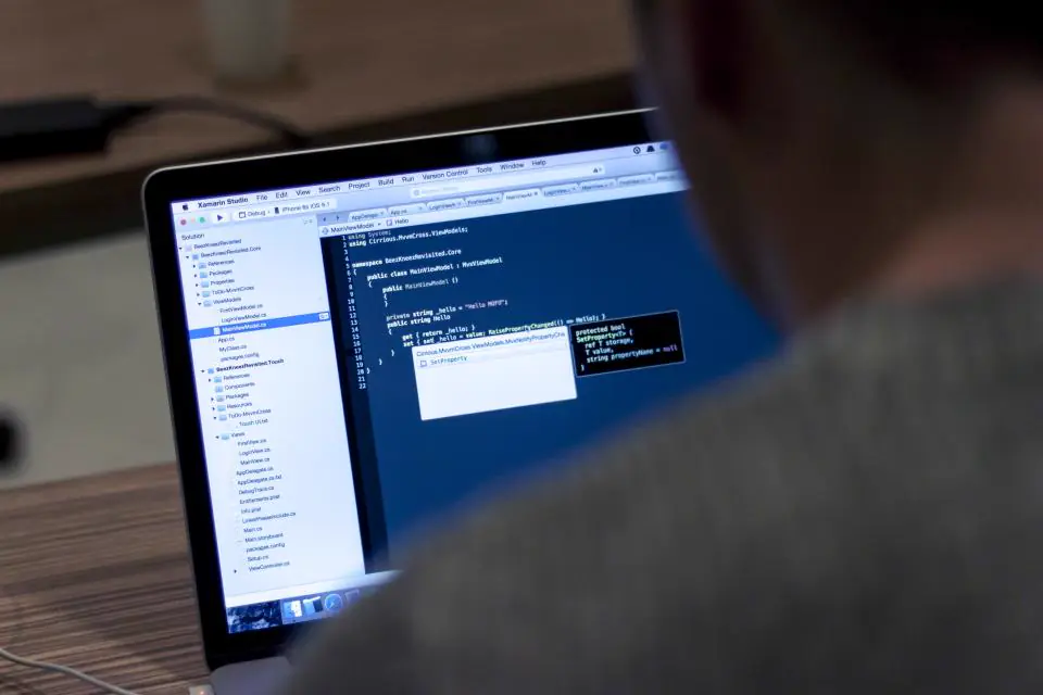 Una persona revisa código en la pantalla de un portátil: portada del artículo sobre PHP2Shell, la falla crítica de PHP de octubre de 2026.