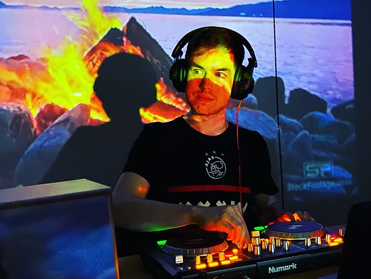 Garrett Gaudet DJing on a Numark controller in front of a projection screen