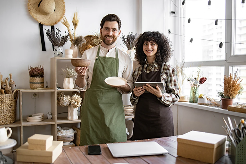 Two people standing together in a small retail shop.
