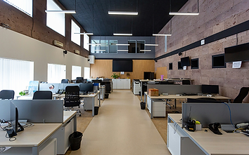 An open-plan office with desks and computer monitors.