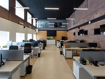 An open-plan office with desks and computer monitors.