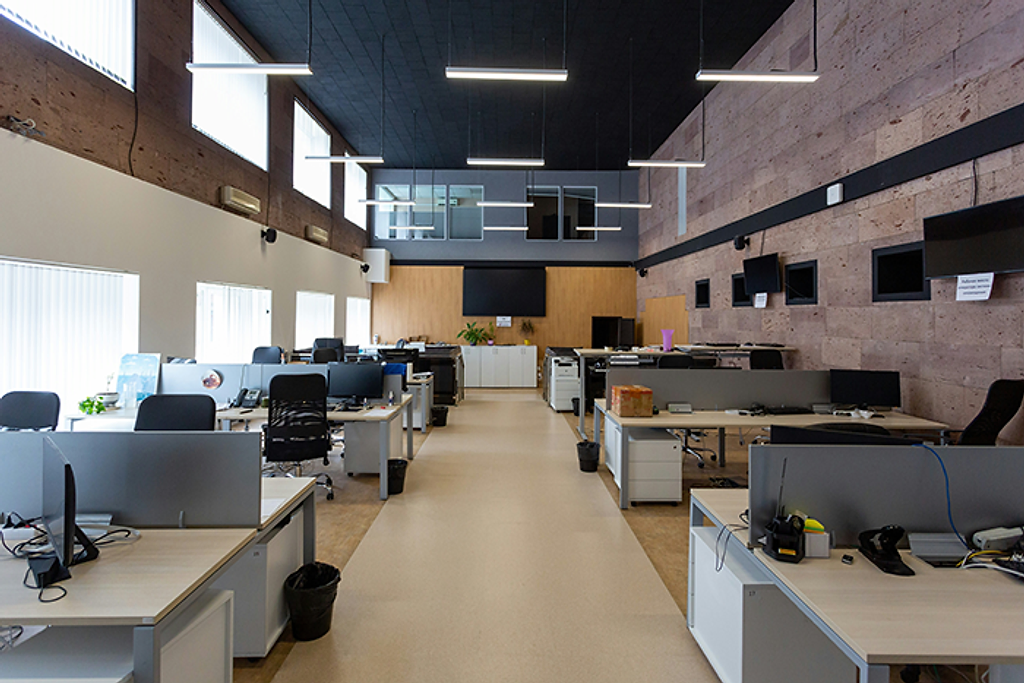 An open-plan office with desks and computer monitors.