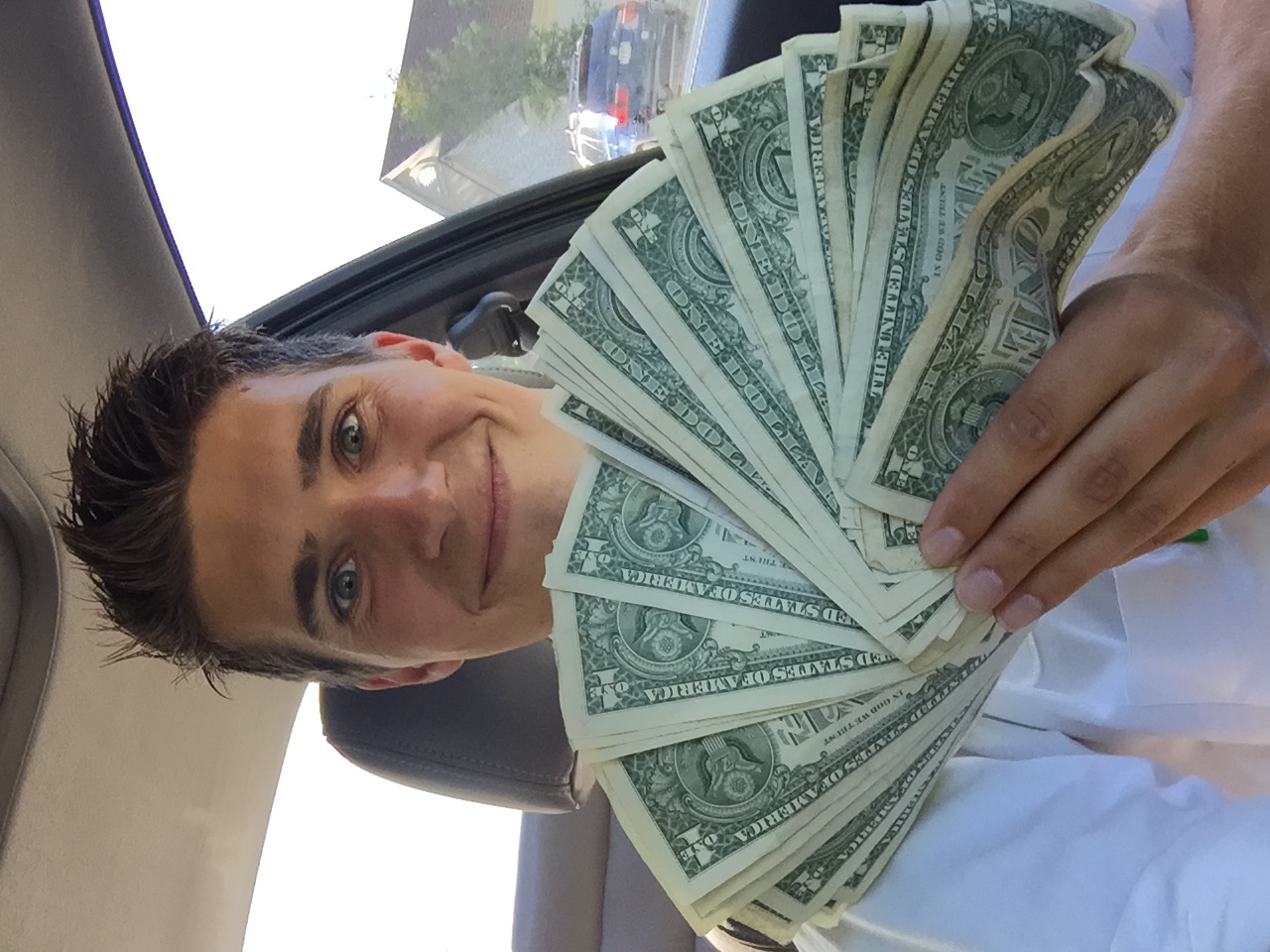 Tyler Evertsen holding a fan of dollar bills during his first summer in door-to-door sales.